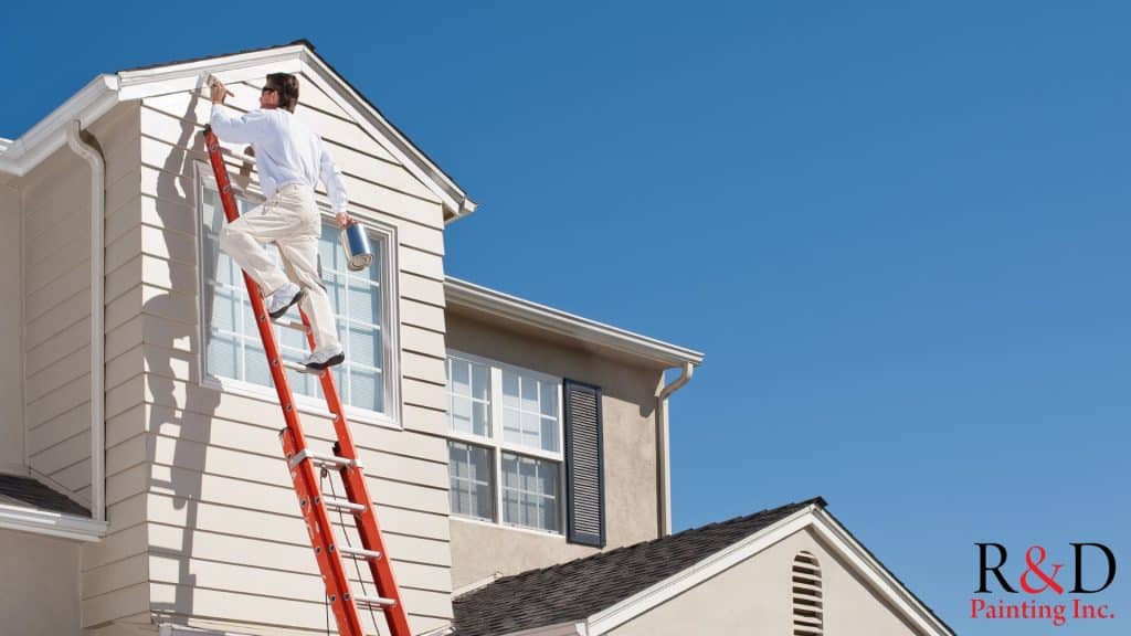 Painters Raleigh NC On An Orange Ladder Painting Exterior Of House